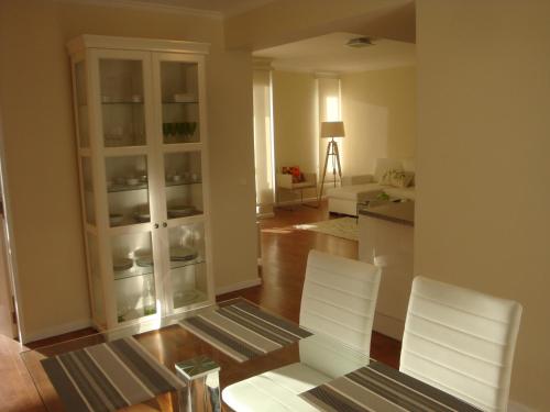 a living room with two white chairs and a kitchen at Listen the sound of the Sea - The Sunset of your Dreams in Funchal