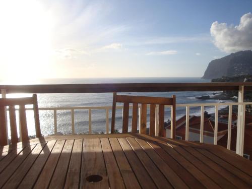 a wooden deck with a view of the ocean at Listen the sound of the Sea - The Sunset of your Dreams in Funchal