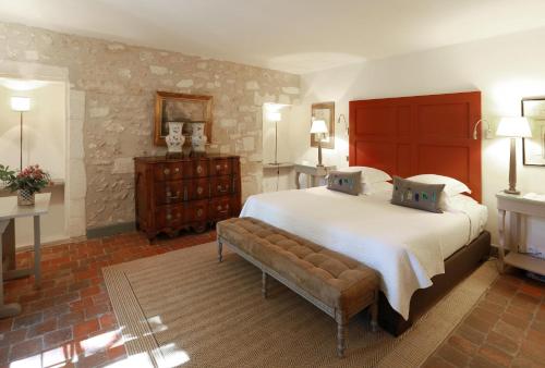 a large bedroom with a large bed and a bench at Baumanière - Les Baux de Provence in Les Baux-de-Provence