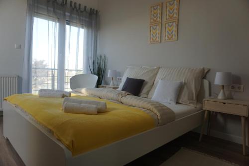 a bedroom with a bed with a yellow blanket at Airport Almáskert Panzió in Vecsés