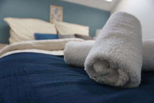 a pair of towels on the edge of a bed at Airport Almáskert Panzió in Vecsés