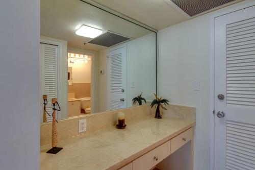 a bathroom with a sink and a large mirror at 2 Beds 2 Baths Beachfront Condo with direct Beach Access in Miami Beach