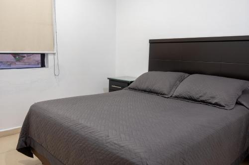 a bedroom with a large bed with a black headboard at Apartamentos Torre II Condominios - Pet Friendly in Mazatlán