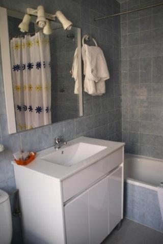 a bathroom with a sink and a mirror and a tub at Hotel Restaurante Valdevenados in Anguiano