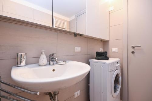 Un baño con lavabo y lavadora. en Al Ponte, en Saló