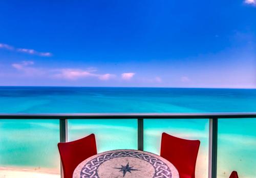 a table and chairs on a balcony with the ocean at Castle Ph3 in Miami Beach