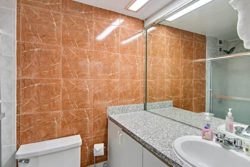 a bathroom with a sink and a toilet and a mirror at Oceanfront Townhouse with direct access to the Beach! Steps from the sand! in Miami Beach