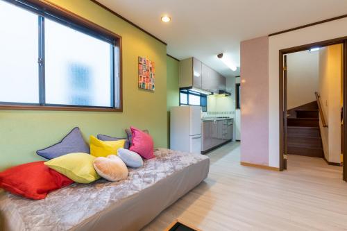 a room with a bed with colorful pillows on it at Asakusa Skytree View House in Tokyo