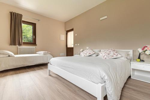ein Schlafzimmer mit einem großen weißen Bett und einem Fenster in der Unterkunft B&B ul calus in Crodo