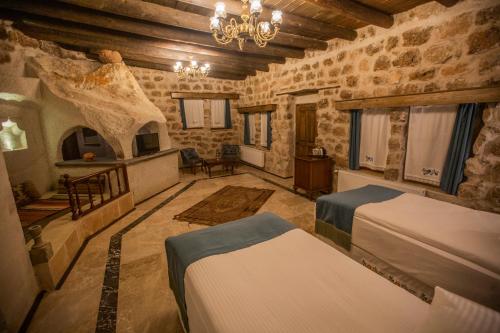 a bedroom with two beds in a stone building at Lavender Cave Hotel in Nevşehir