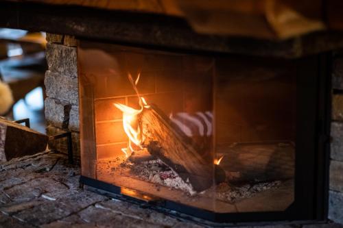 Una chimenea de ladrillo con fuego. en Chalet La Grange à Germaine - Propriétés Mont Amour, en Avoriaz