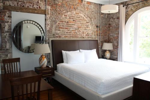 a bedroom with a bed and a brick wall at Hotel Hale in Hot Springs