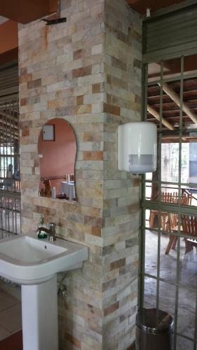 a bathroom with a sink and a brick wall at MakanHill Resort Hotel in Mityana