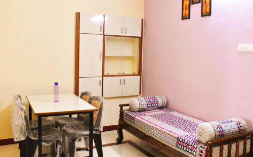 Habitación con sofá y mesa con sillas. en Sannidhi Service Apartments, en Tirupati