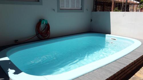 a hot tub with a hose attached to a house at Hostel na Rota da Serra Gaúcha in Taquara