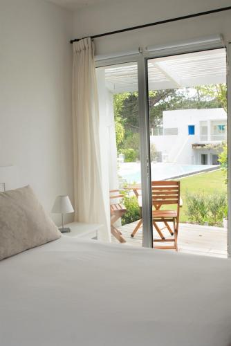 a bedroom with a bed and a large window at Kalá Hotel Boutique in Punta del Este