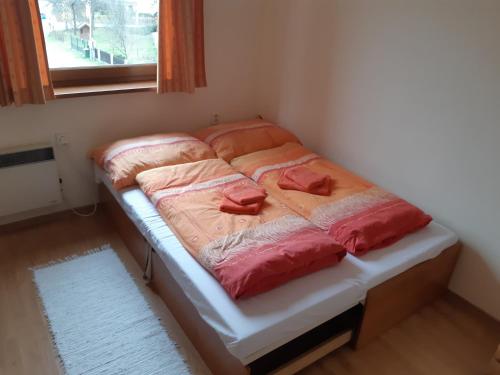 a twin bed in a room with a window at Apartmán Borgi in Oščadnica