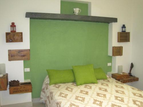a bedroom with a green wall and a bed with green pillows at casammare in Paola