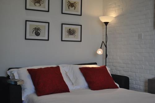 a bedroom with a bed with two red pillows on it at Luxury Suite - Amazing Views & Lovely Garden in Salalah
