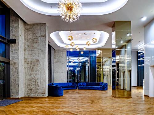 a lobby with blue couches and a chandelier at Union Plaza Hotel in Bucharest