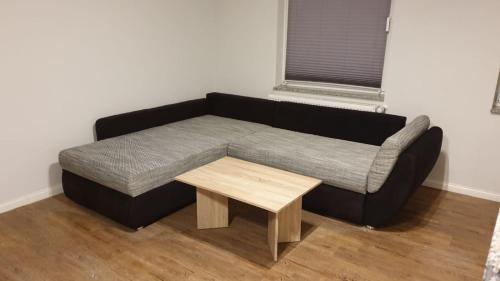 a black couch with a coffee table in a room at Monteurwohnung in Zerbst