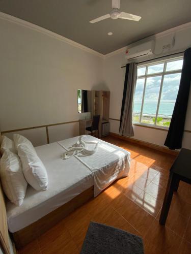 a bedroom with a bed and a large window at String Wave Maldives in Gulhi