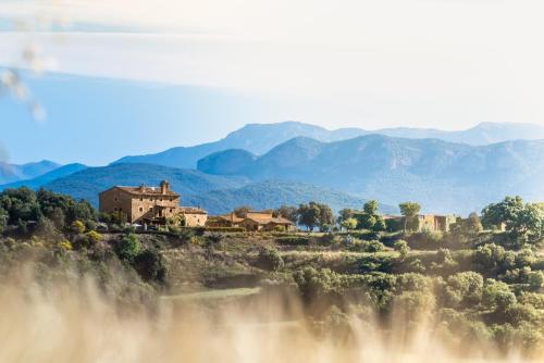 索爾索納的住宿－Casa rural Sant Grau turismo saludable y responsable，山丘上的一座古老房子,背景是群山