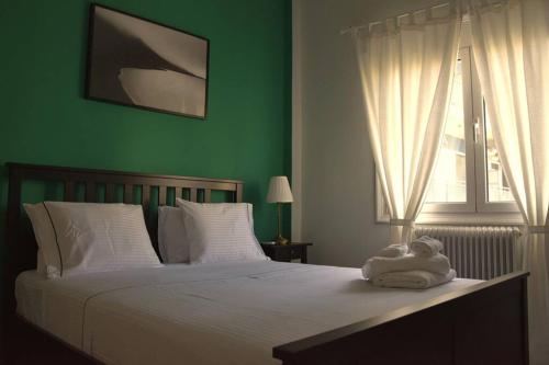 sypialnia z białym łóżkiem i zieloną ścianą w obiekcie City Life Apartments #3 w mieście Janina