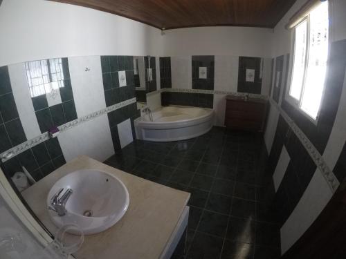 a bathroom with a tub and a sink and a bath tub at Villa Les Cocotiers in Nosy Be