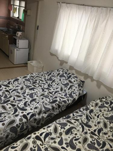 a bedroom with a bed with a black and white comforter at Utopia Wakamiya 207 / Vacation STAY 5372 in Fukuoka
