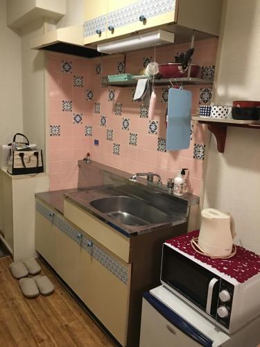 a small kitchen with a sink and a microwave at Utopia Wakamiya No.105 / Vacation STAY 5161 in Fukuoka