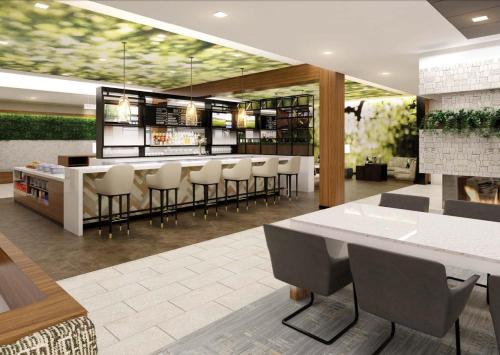 a restaurant with a bar with stools at Wyndham Garden Sacramento Airport Natomas in Sacramento