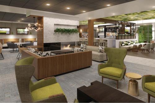 a lobby with a waiting area with chairs and tables at Wyndham Garden Sacramento Airport Natomas in Sacramento