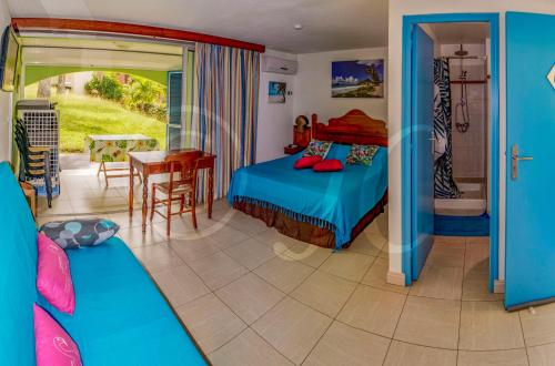 a bedroom with a bed and a dining room with a table at Hauts de Caritan in Sainte-Anne
