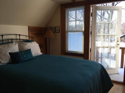 a bedroom with a blue bed and a window at Baxter House Bed & Breakfast and Apartment in Ann Arbor