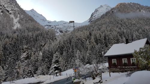 a cabin in the mountains with snow on the trees at Gästehaus Alpenglühn in Meien