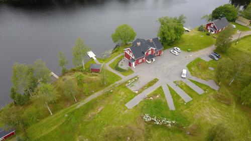 a house on top of a hill next to a river at River Lodge in Ludvika