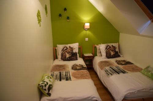 two beds in a room with green walls at Forêt de nieppe in Merville