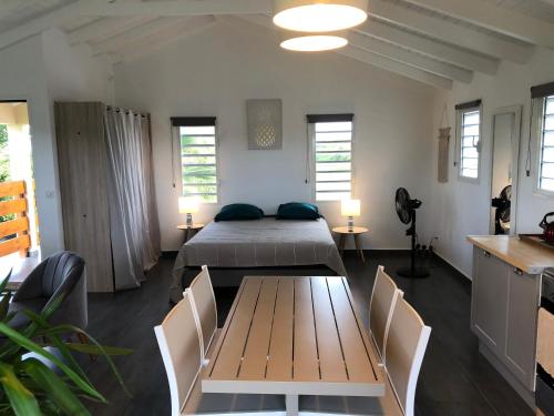 a bedroom with a bed and a table and chairs at Loft Paradis in Sainte-Anne
