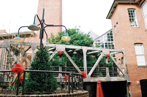 a group of christmas trees in front of a building at The Historic Brookstown Inn, Trademark Collection by Wyndham in Winston-Salem