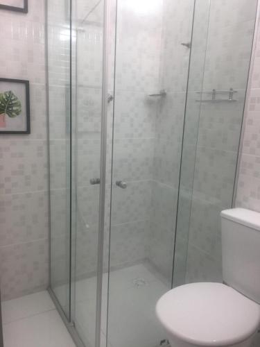 a bathroom with a glass shower with a toilet at Hotel Miranelli in Barbacena