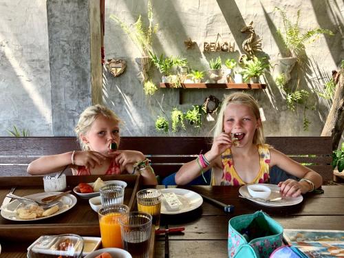 two young girls sitting at a table eating food at Sand in My Shoes Beach Loft in Thong Nai Pan Noi