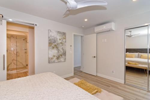 a white bedroom with a bed and a bathroom at Ocean Villas Beach Front in Carlsbad