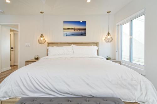 a white bedroom with a large white bed at Ocean Villas Beach Front in Carlsbad
