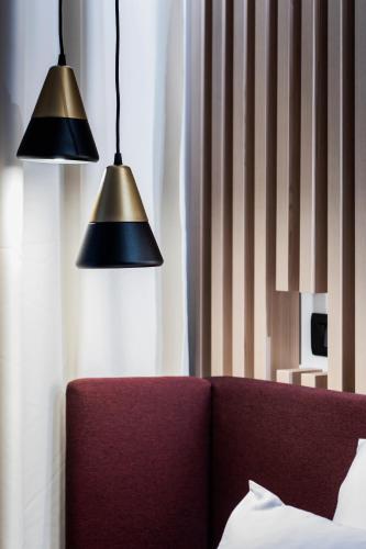 two lights hanging above a couch in a room at Pod Zidom Rooms in Zagreb