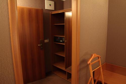 a closet with a door open and a wooden chair at Hotel Lipa in Bojnice
