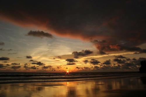 a sunset on the beach with the sun setting at Punta Brava in Nuquí