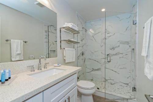 a bathroom with a shower and a toilet and a sink at Ocean Villas Beach Front in Carlsbad