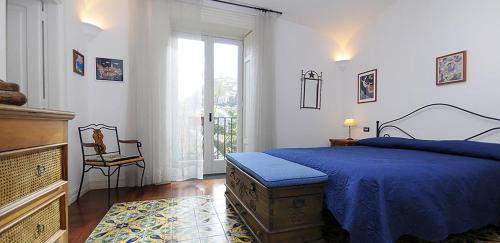 sypialnia z niebieskim łóżkiem i oknem w obiekcie AMORE RENTALS - Villa Angelo w mieście Sant'Agnello