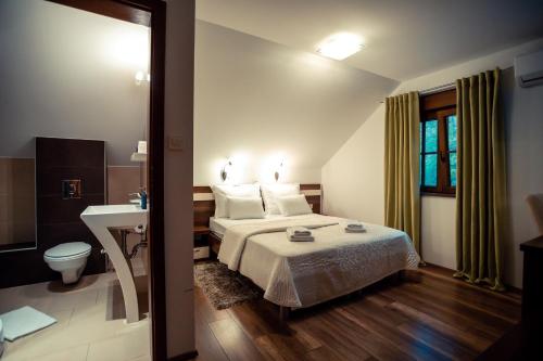 una camera con letto, servizi igienici e lavandino di Golden Lakes Rooms a Laghi di Plitvice